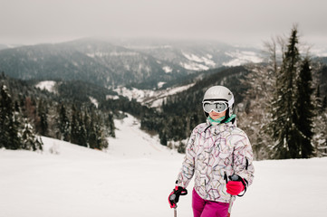 Fototapeta na wymiar Skiing. Good skiing in the snowy mountains. Woman in ski mask on skis on snow in Carpathian. On background of forest and ski slopes. Close up. Winter nature. Nice winter day.