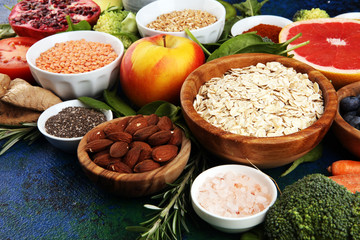 Healthy food clean eating selection: fruit, vegetable, seeds, superfood, cereals, leaf vegetable on rustic background