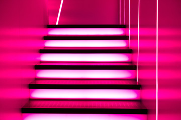 Illuminated futuristic staircase in neon lights in the club