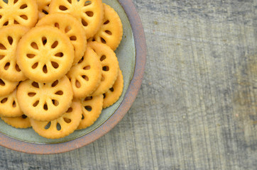 Delicious biscuits in plate on wooden background
