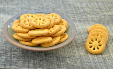 Delicious biscuits in plate on wooden background