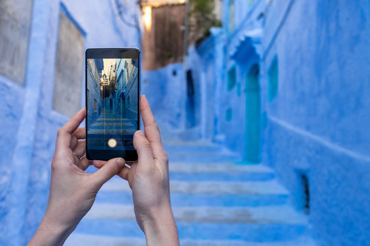 Woman holding smartphone and making street photo