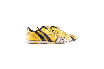 Old  worn out dirty yellow futsal sports shoes  on white background football sportware object...