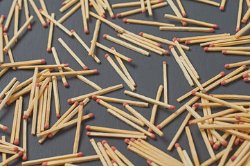 Scattered many matches with red sulfur on dark concrete desk on kitchen. Close-up
