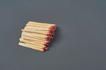 Heap of many matches with red sulfur on dark concrete desk on kitchen. Space for text