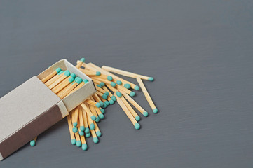 One cardboard matchbox of many matchsticks with green sulfur on dark concrete table on kitchen....
