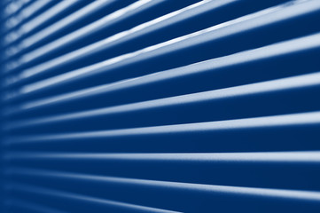 Classic blue tone close-up modern plastic shutter blinds in office room. trendy 2020 color pantone...