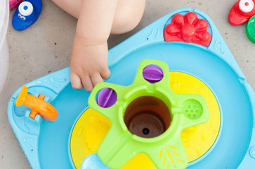 Child's hand playing with colorfull water game