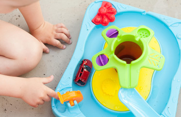 Child's hand playing with colorfull water game
