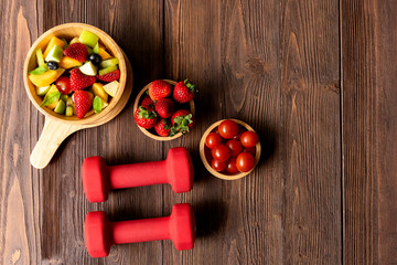 Healthy Fruits. Fresh fruits salad diet slim fit with dumbbells sport equipment for healthy lifestyle women. Weight Loss and Diet Concept