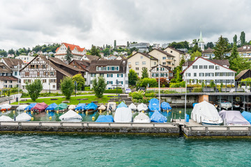 Fototapeta na wymiar Boats parking on the lake of Zurich, with background of beautiful building on the lakeshore in Zurich, Switzerland.