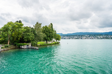 Fototapeta na wymiar Beautiful lake Zurich landscape. Cloudy skyscape with background of Alps mountains peaks.