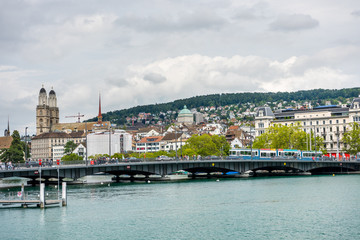 View of the historic buildings and bridge of Zurich at the bank of Limmat River and Zurich lake, with landmark of Zurich University, and Grossmunster (Great Church)