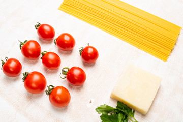Italian spaghetti pasta and fresh ingredients on a rustic wooden background