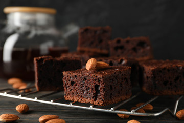 Chocolate cake slices, teapot and almond on wooden background, close up