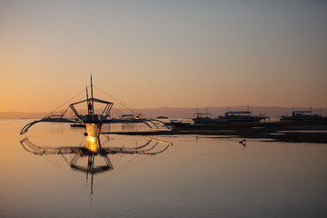 Beautiful amazing nature background. Tropical  sea at the sunset light, Bohol Island. Philippines traditional fishing boats.