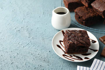 Composition with chocolate cake slices on blue background, space for text
