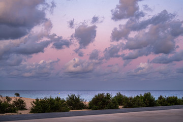Fototapeta premium Pink sky with clouds over the sea during the sunset at the beach.