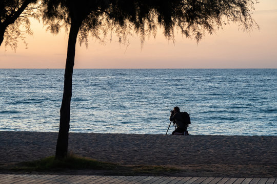 Silhouette of photographer on the beach during sunset