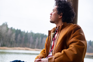 Latin American man looking relaxed at a lake 
