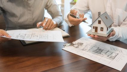 House model with agent and customer discussing for contract to buy, get insurance or loan real...