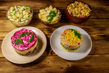Set of festive mayonnaise salads on wooden table