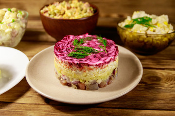 Set of festive mayonnaise salads on wooden table