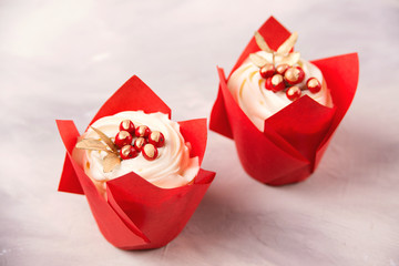 Delicious two cupcakes in red paper decorated with berries. Valentine day celebration