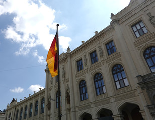 Fototapeta na wymiar Germany flag on flagpole before facade of Five Continents Museum in Munich on bright sunny day