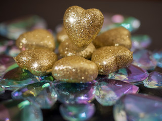 Golden hearts with glitter on a glass snowflake, Saint Valentine theme background.