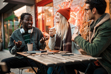 Smiling Afro American guy telling something fun to friends