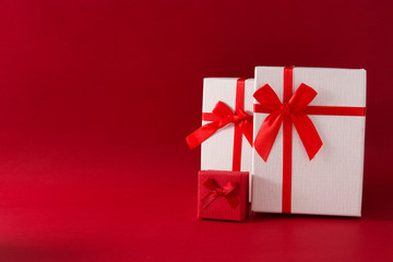 Assorted white gift boxes on red background. Copy space	