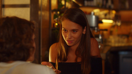 Slow motion, girls sit at a table in a cafe, they eat and talk to each other