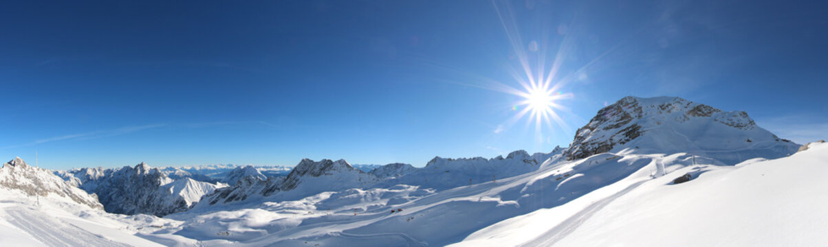 A beautiful view over the german and austrian alps from the mountain 'zugspitze' in a winter wonderland with blue sky