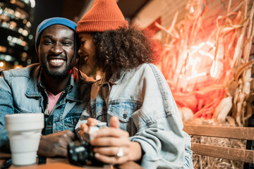 Pretty Afro American lady near her boyfriend in street cafe