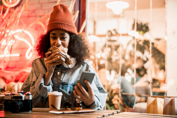 Happy pretty lady biting a snack in street cafe