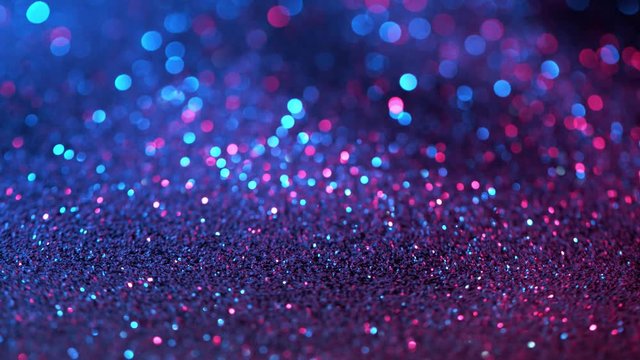 Super slow motion of sparkling abstract glittering background in neon colours. Filmed on very high speed camera, 1000 fps.