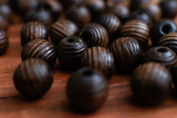 brown beads on a wooden tray and a white table