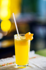 Fresh tropical mango juice in a glass decorated with a carambola slice.