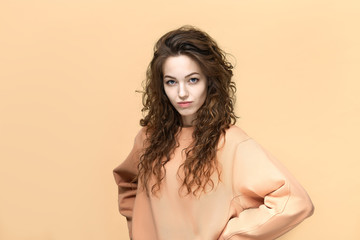 Portrait of a young beautiful woman wearing sweatshirt posing isolated over yellow background