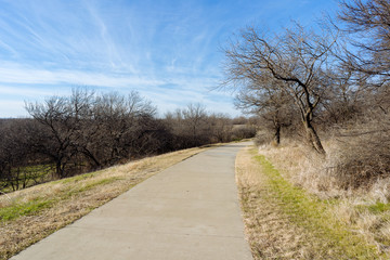 Fototapeta na wymiar Concrete walkway in a Texas city reserve on a sunny December day.