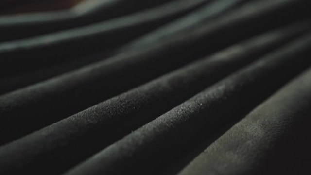 Rolls of leather in different colors on the table. Soft daylight falling on it. Closeup shot. 