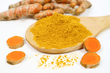 Turmeric powder in a wooden spoon