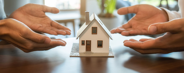 House model with agent and customer discussing for contract to buy, get insurance or loan real...
