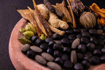 Macro shot of herbs and spices with herbal medicines on a grinding stone. Unani concept