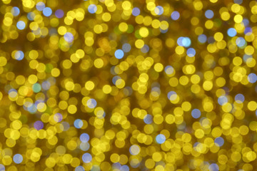 Defocused photography of colorful Christmas lights in night. Impressionism style. Twinkle of white, gold and blue lights. Suitable as background for miracle creative template