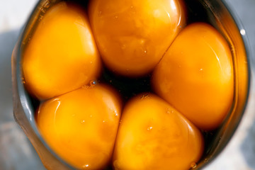Bright egg yolks in a Japanese marinade in a glass, macro shot.