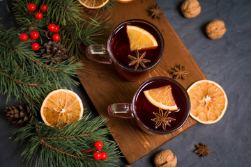 Red spicy Christmas mulled wine based on red wine with orange and spicy cinnamon sticks, star anise, on a black background. Recipe for seasonal drinks. The view from the top.