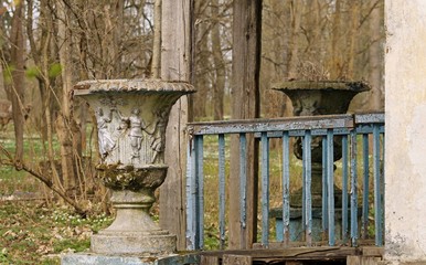 Vintage flower vases at the dilapidated porch of an abandoned maison