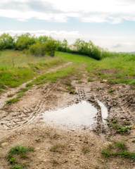 Puddle in a trail in the mountains of Croatia, Istria, with signs of  tires of off road vehicles like jeep cars bike motorbike 